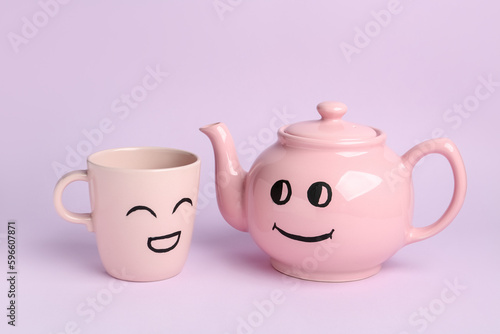 Cup and teapot with happy faces for Friendship Day on pink background