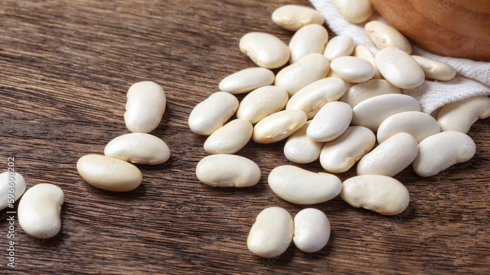 Pile of white beans closeup on wooden table Pile of white beans closeup on wooden table