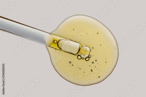 Foto Cosmetic texture serum emulsion drop with pipette dropper yellow