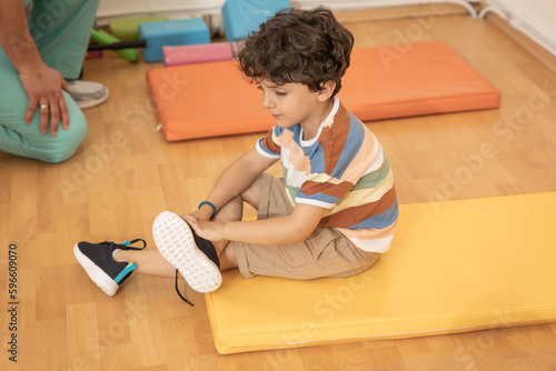 Photography Kid putting on shoes in kindergarten