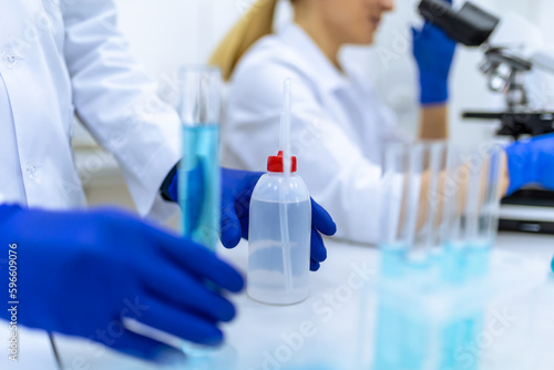 Scientists examining liquid in test tube in laboratory