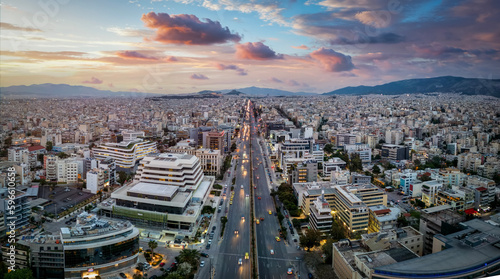 Fototapeta Naklejka Na Ścianę i Meble -  Aerial view of the skyline of Athens, Greece, during sunset time with Syggrou Avenue leading from the south suburbs in to the city center