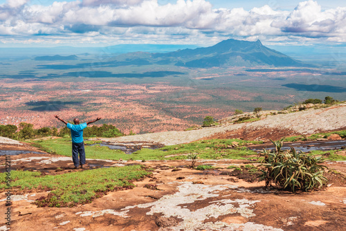 A hiker at a scenic view point against the background of Mount Longido, Tanzania