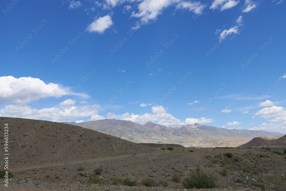 Panoramic view of the plain in the mountains, in variable weather. Nature of the Altai Mountains. Beautiful wallpaper.