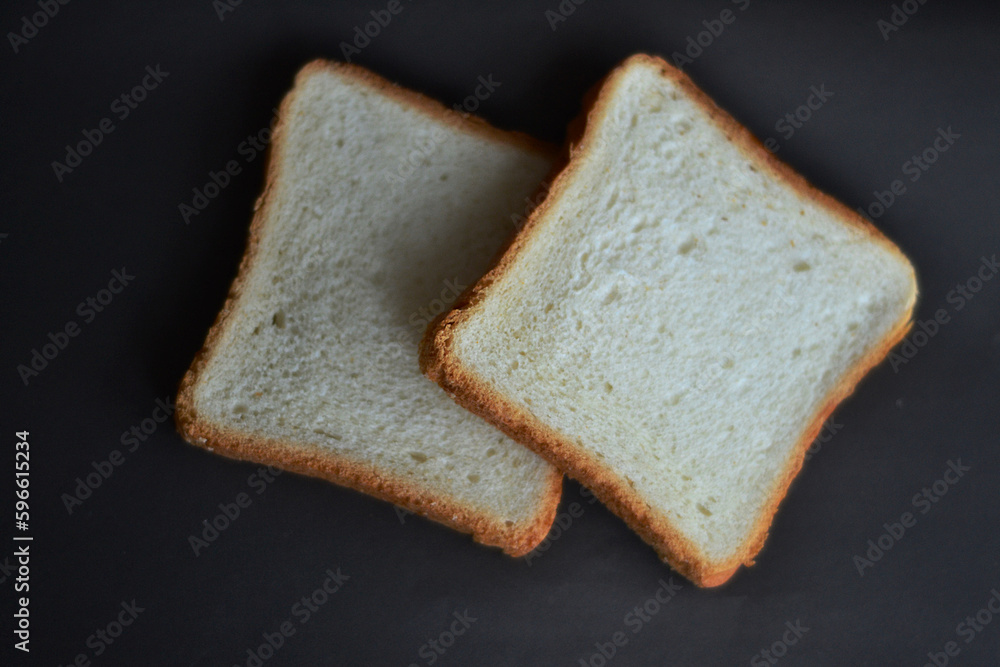 Two pieces of bread on a black background Two pieces of bread on a black background