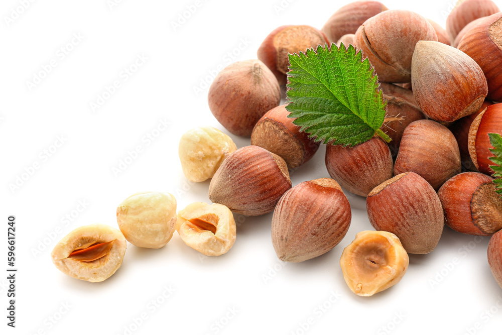 Shelled hazelnuts with leaf on white background Shelled hazelnuts with leaf on white background