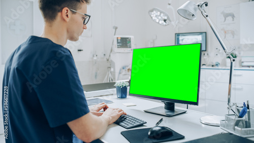 Veterinary Clinic Doctor Working on a Desktop Computer with Green Screen Mock Up Display © Gorodenkoff