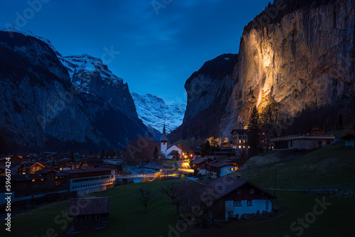 frühe blaue Stunde in Lauterbrunnen in der Schweiz mit beleuchtetem Wasserfall