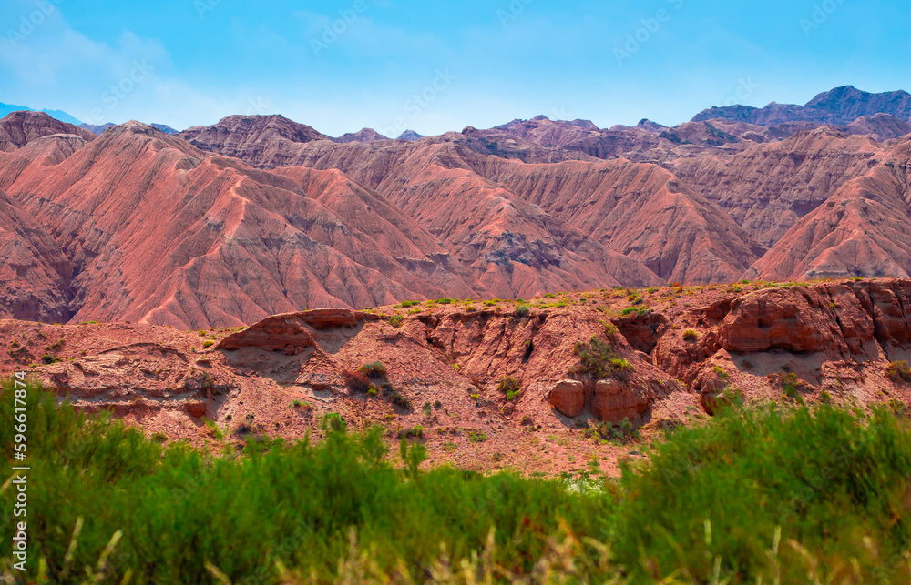 Natural unusual landscape of red rocks against the backdrop of blue mountains. The extraordinary beauty of nature is similar to the Martian landscape. Amazingly beautiful landscape. Natural unusual landscape of red rocks against the backdrop of blue mountains. The extraordinary beauty of nature is similar to the Martian landscape. Amazingly beautiful landscape.
