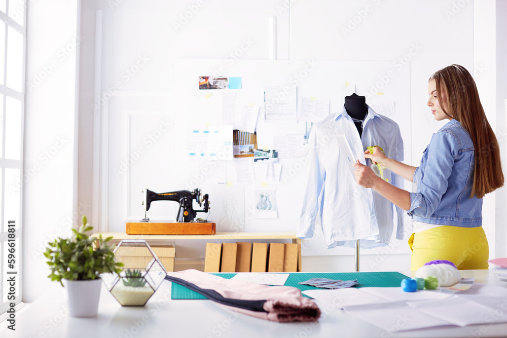 Attractive young woman are in process of creating new clothes collection. Attractive young woman are in process of creating new clothes collection.
