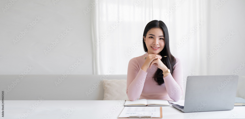 Portrait of the beautiful asian businesswoman , she is sitting at the table at workstation Portrait of the beautiful asian businesswoman , she is sitting at the table at workstation