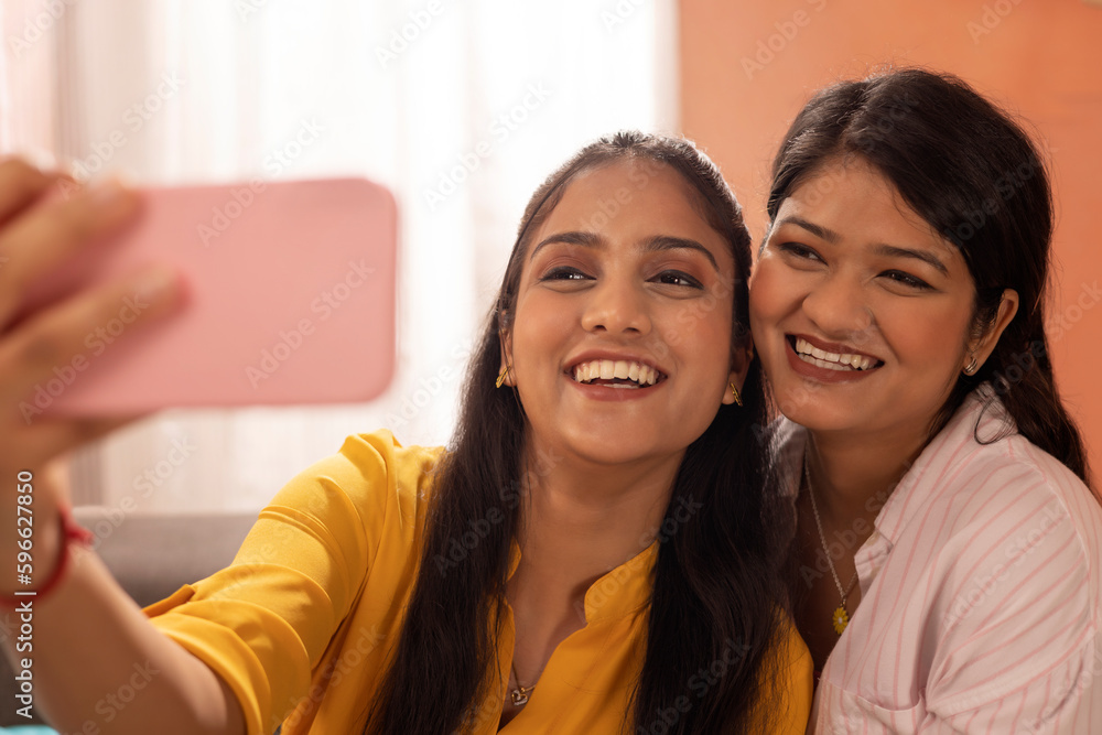 Close-up portrait of two smiling young women taking selfie together Close-up portrait of two smiling young women taking selfie together