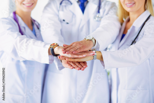 Doctors and nurses in a medical team stacking hands.