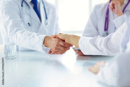 Doctor shaking hands with a male patient in the office.