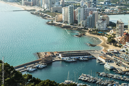 modern apartments, Cantal Roig beach and sailboats and fishing boats in the port of Calpe. Top view, horizontal