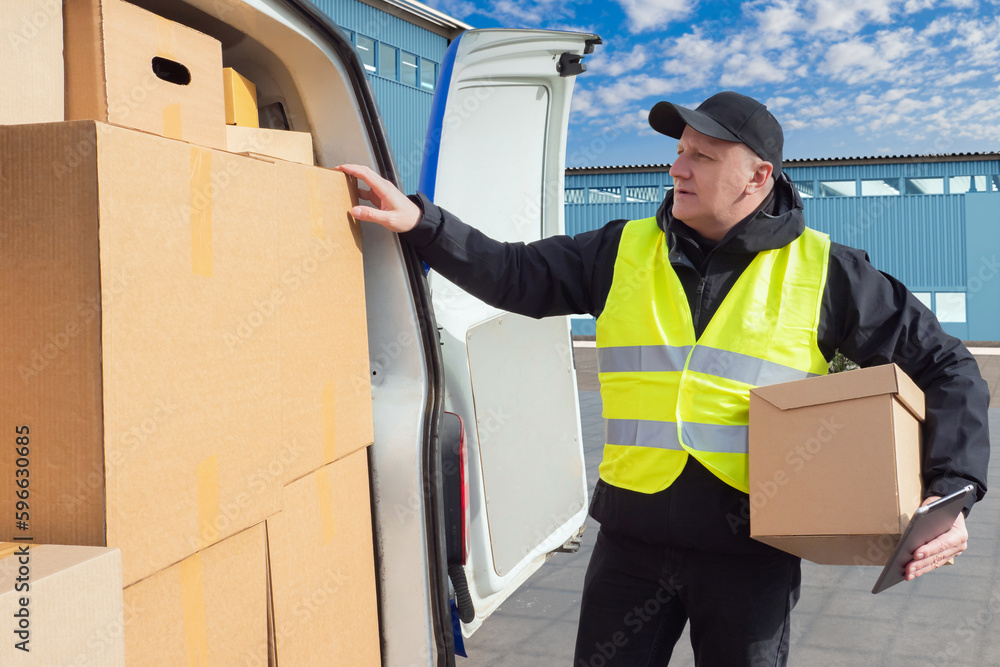 Male courier. Guy with box. Minivan and delivery man. Cardboard boxes