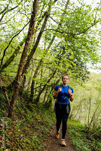 Pretty young woman in sportswear doing a trail in the mountains near the Holtzate Gorge