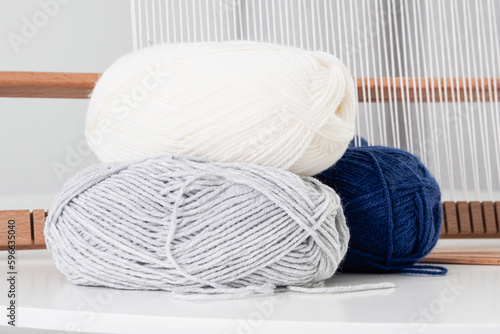 Woolen yarn on the background of a loom with stretched threads. Threads on a white background. coarse yarn