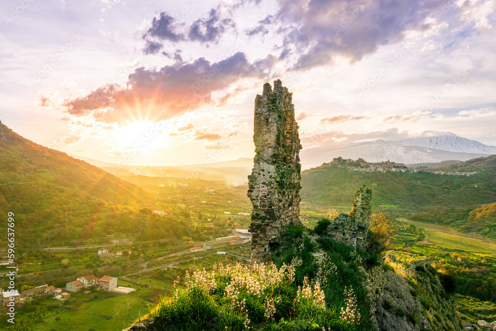 beautiful medieval castle ruins on mountain during nice sunset or sunrise with highland landscape on background