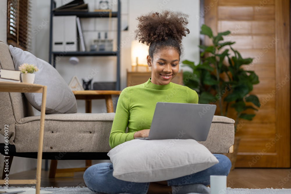 An American teenage woman is in the living room, she is spending her weekends at home playing social media and watching movies. The concept of living on vacation. An American teenage woman is in the living room, she is spending her weekends at home playing social media and watching movies. The concept of living on vacation.