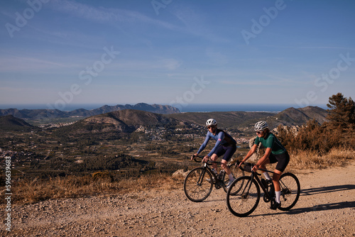 Gravel adventure.Two cyclists are riding along a scenic mountain gravel route.Cyclists are practicing on gravel road.Beautiful sunny day for cycling.Spain.