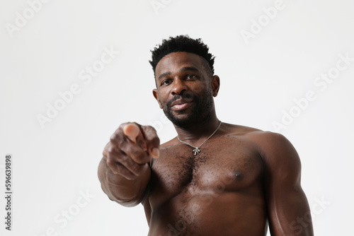 African American athletic man shirtless pointing at the camera. Mock-up.