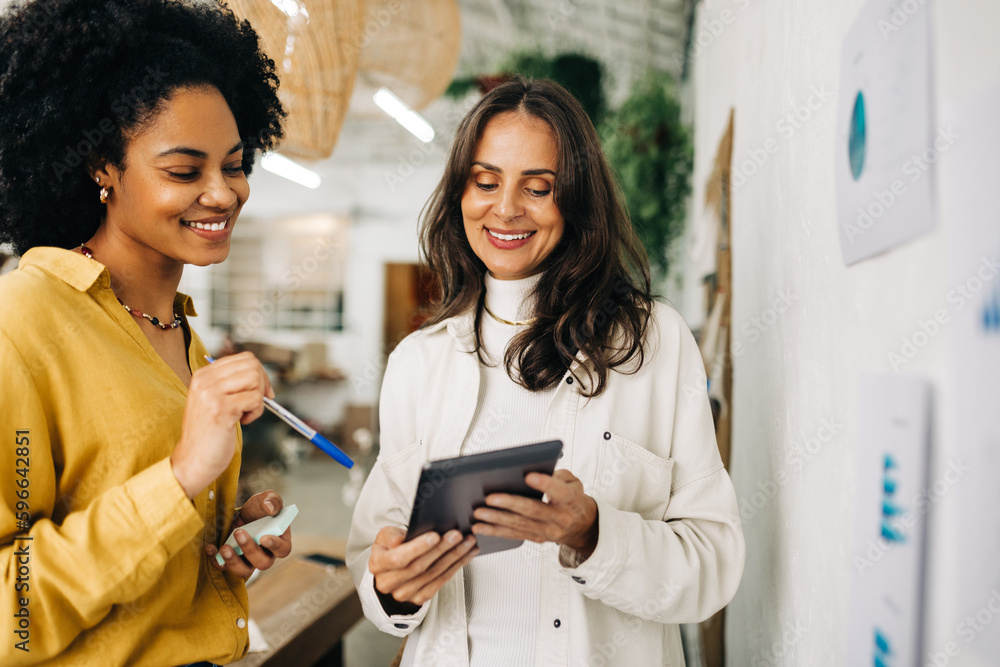 © (JLco) Julia Amaral - Female entrepreneurs using a tablet together as they brainstorm in an office © (JLco) Julia Amaral - Female entrepreneurs using a tablet together as they brainstorm in an office