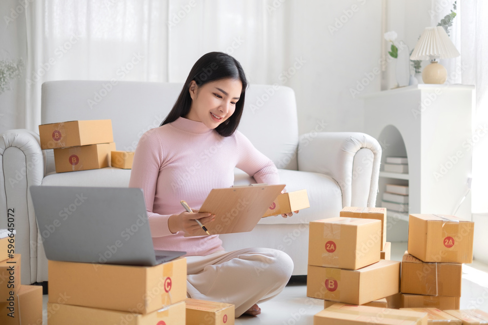 Entrepreneur, small business, SME, freelance woman working from home with lots of boxes on the side. Entrepreneur, small business, SME, freelance woman working from home with lots of boxes on the side.