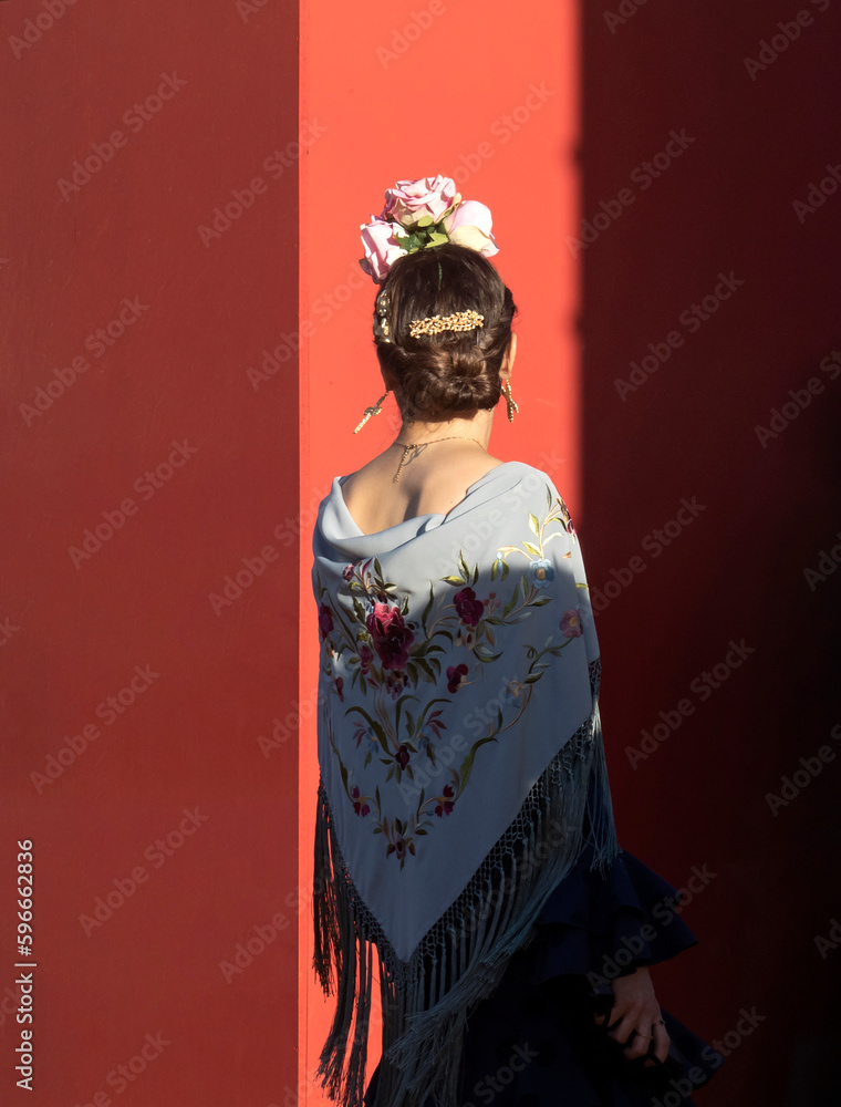 Fototapeta premium Título: Mujer vestida de flamenca entrando en la Feria de Abril de Sevilla. 2023 / Woman dressed as a flamenco woman entering the April Fair in Seville. 2023