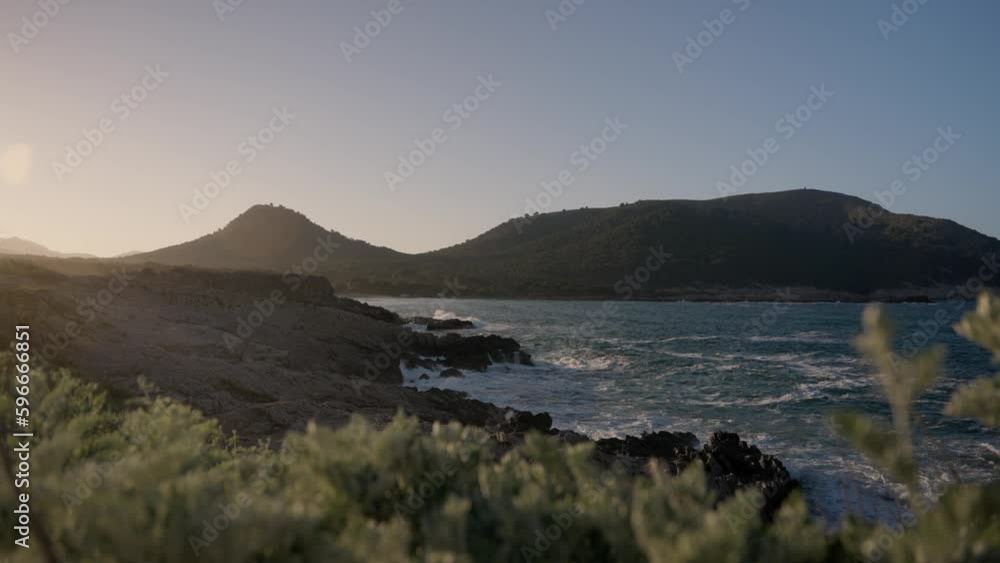 Calm and beautiful coast shore line scenery with crashing waves and clear water at golden hour sunset Calm and beautiful coast shore line scenery with crashing waves and clear water at golden hour sunset