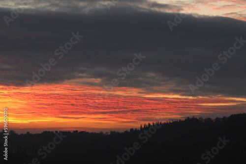 tramonto su una collina con nuvole rosse © Simona