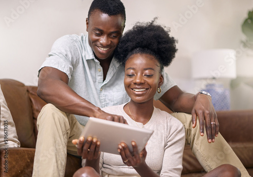 Would you look at this. Shot of a young couple using a digital tablet together at home.