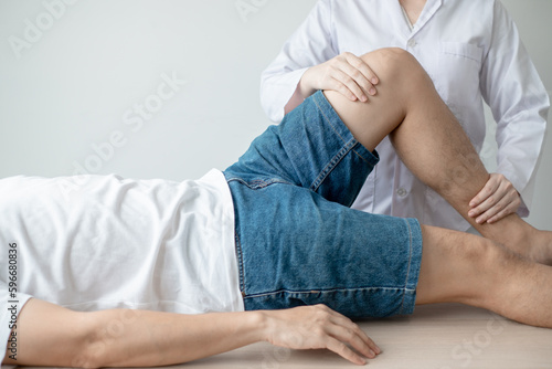 Therapist treating test the strength of the leg muscles of male patient.