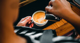 Close-up of the hand of a professional barista in a coffee shop making  pouring steamed milk into the coffee cup making latte menu