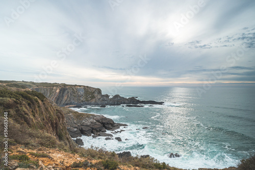Rugged rock and cliff coastline on the Atlantic Ocean near the town of Odeceixe in the west of Portugal in the famous tourist region of the Algarve. Sunset
