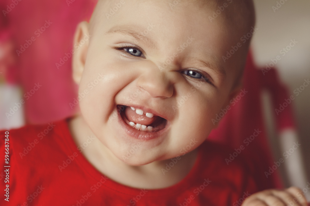Portrait of happy laughing baby in red with blue eyes Portrait of happy laughing baby in red with blue eyes