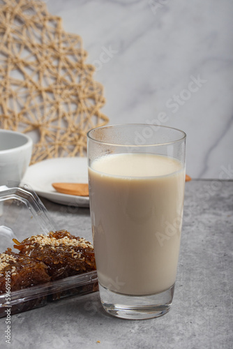 Hot fresh milk in transparent glass on gray background