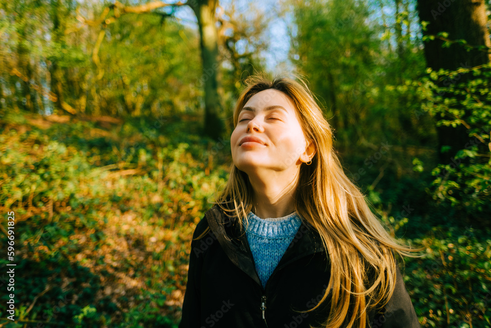 Attractive caucasian woman breathe fresh air , enjoying springtime on a sunset in natural parkland Attractive caucasian woman breathe fresh air , enjoying springtime on a sunset in natural parkland