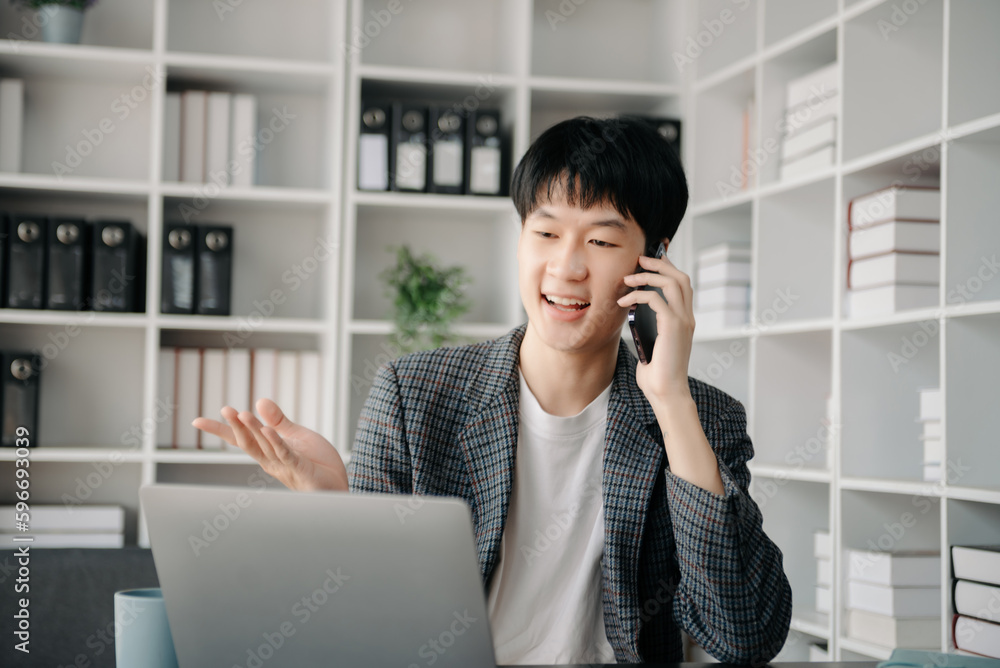 Portrait of young man sitting at his desk in the office Portrait of young man sitting at his desk in the office