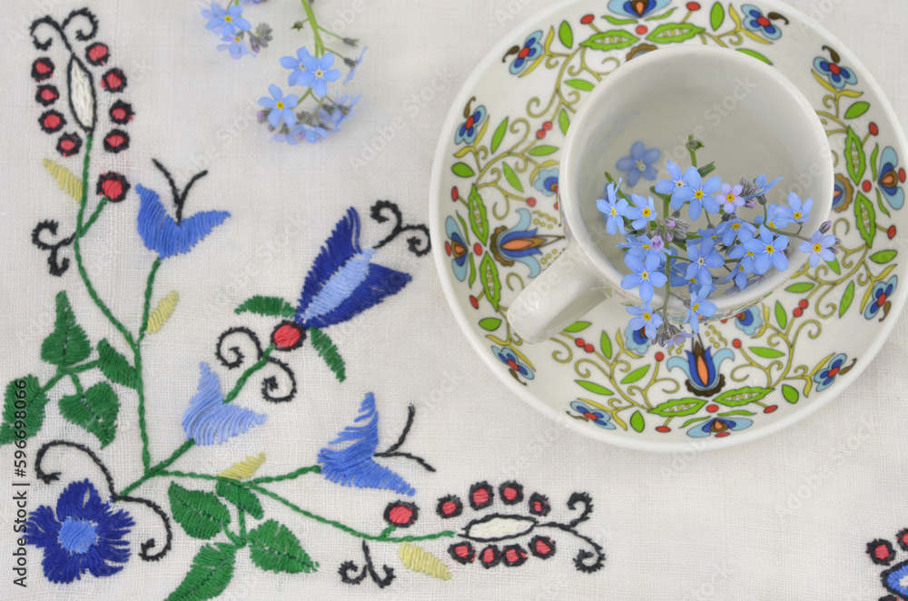 Floral, traditional, ethnic pattern on cup and on tablecloth. Kashubian folklore. - obrazy, fototapety, plakaty 