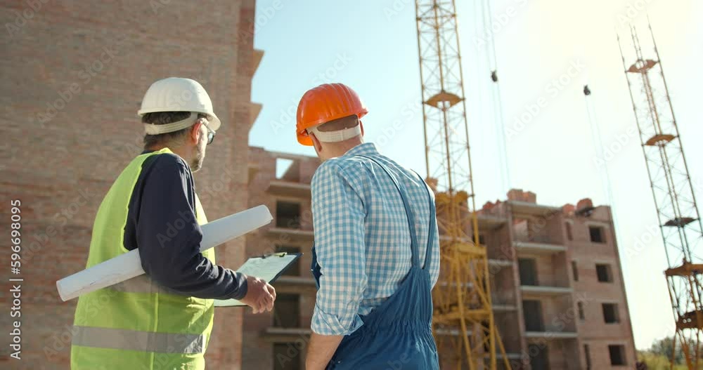 Engineer and worker looking at notepad at construction Engineer and worker looking at notepad at construction