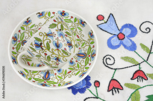 Cup with a traditional, regional pattern on a tablecloth with ethnic, traditional embroidery from Kashubia in Poland.