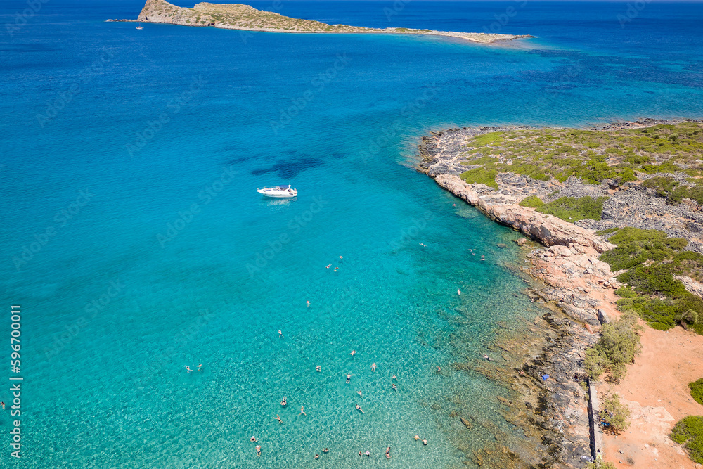 Aerial view of a small beach and clear, blue ocean on the Greek island of Crete