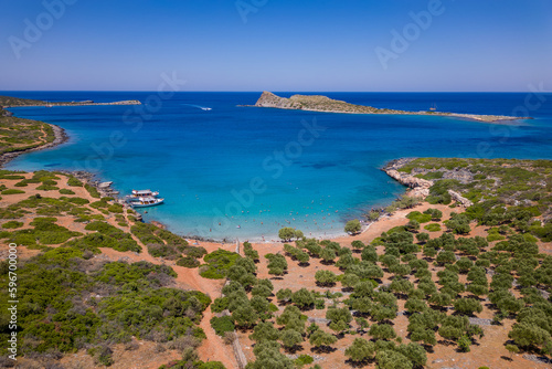 Aerial view of a small beach and crystal clear ocean with swimmers on a hot summers day in Crete (Kolokitha)