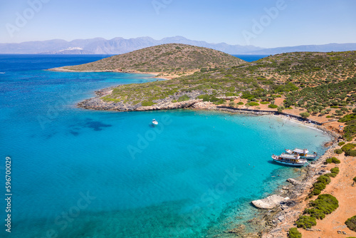 Aerial view of tourist boats and swimmers in crystal clear waters off a small beach (Kolokitha, Crete, Greece)