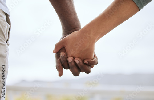 Photos Closeup of biracial couple interlocking fingers and holding hands while bonding outdoors
