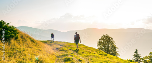A man and a woman are walking along a tourist route high in the mountains. Beautiful background for a banner. Weekend travel