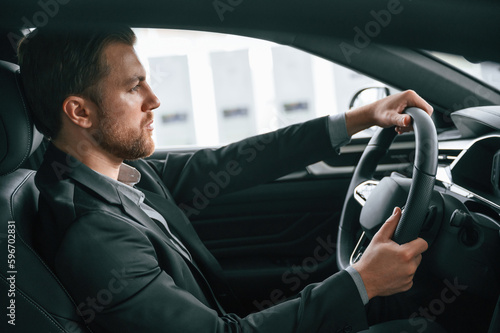 Test drive. Man in formal business clothes is sitting in the modern automobile © standret