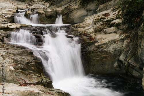 Autumn waterfall in a small rocky river. Motion blur.