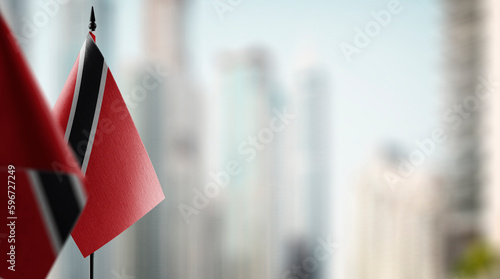 Small flags of the Trinidad and Tobago on an abstract blurry background
